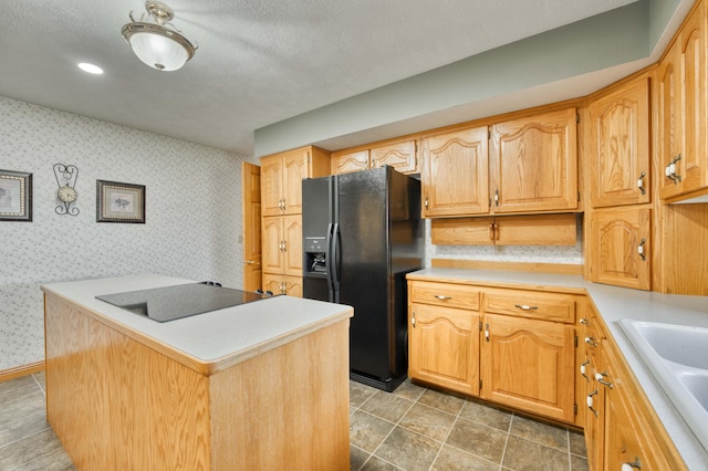 9169 W Farm Road 60, Willard, MO 65781 - kitchen featuring black fridge with ice dispenser, a sink, stovetop, wallpapered walls, and light countertops