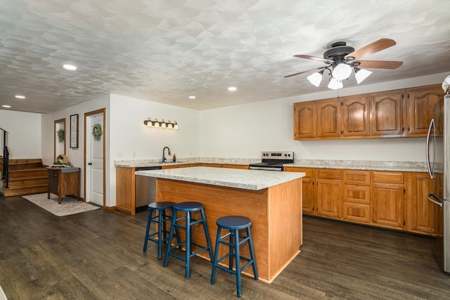 4216 Skyline Rd, Seymour, MO 65746 - kitchen with stainless steel appliances, a sink, dark wood finished floors, a center island, and brown cabinets