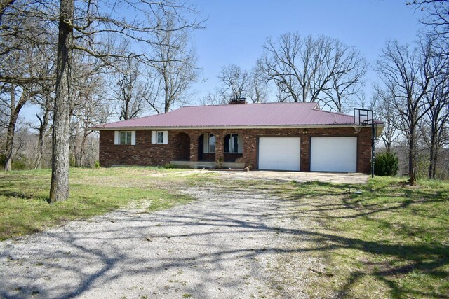 70 Dallion Ford Ln, Buffalo, MO 65622 - view of front of property with driveway, an attached garage, brick siding, a chimney, and metal roof