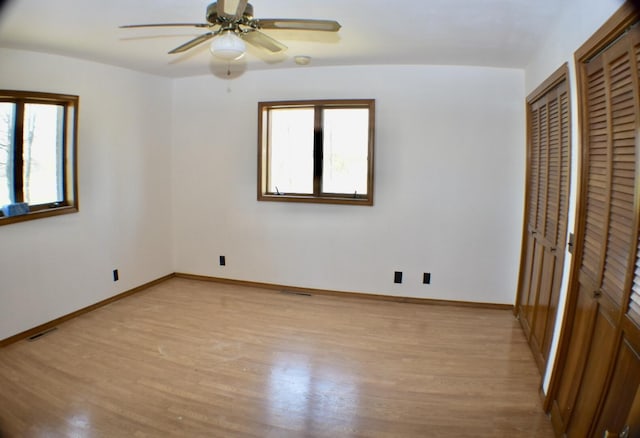 70 Dallion Ford Ln, Buffalo, MO 65622 - unfurnished bedroom featuring two closets, light wood-style floors, multiple windows, and baseboards