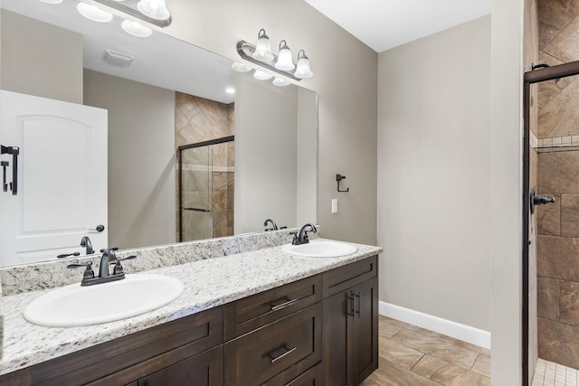 311 Stillwood Dr, Branson, MO 65616 - full bath with a shower stall, baseboards, double vanity, and stone finish floors