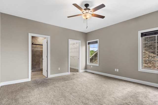 311 Stillwood Dr, Branson, MO 65616 - unfurnished bedroom featuring light colored carpet, baseboards, a spacious closet, ensuite bath, and a ceiling fan