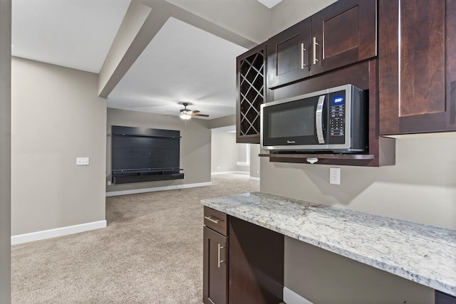 311 Stillwood Dr, Branson, MO 65616 - kitchen with stainless steel microwave, light carpet, baseboards, a ceiling fan, and dark brown cabinetry