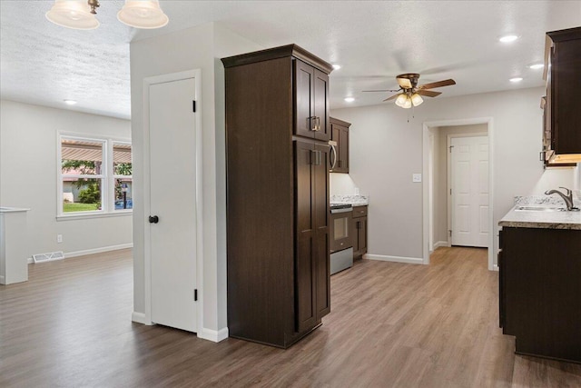3156 N National Ave, Springfield, MO 65803 - kitchen with a sink, dark brown cabinetry, ceiling fan, wood finished floors, and a textured ceiling