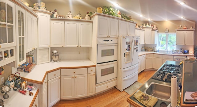 2016 Timberlake Rd, Branson, MO 65616 - kitchen with white appliances, light countertops, light wood-style floors, backsplash, and glass insert cabinets