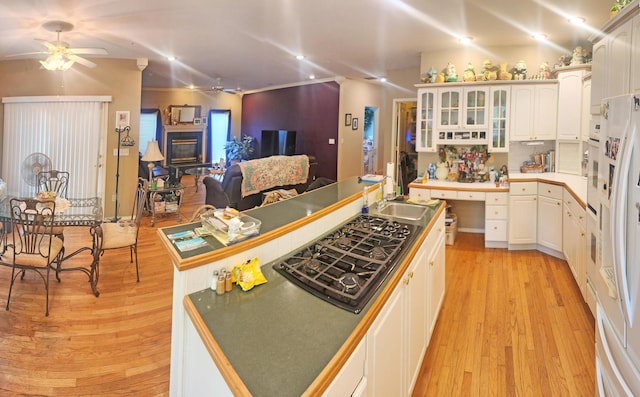 2016 Timberlake Rd, Branson, MO 65616 - kitchen with a ceiling fan, black gas stovetop, light wood-style flooring, glass insert cabinets, and a sink