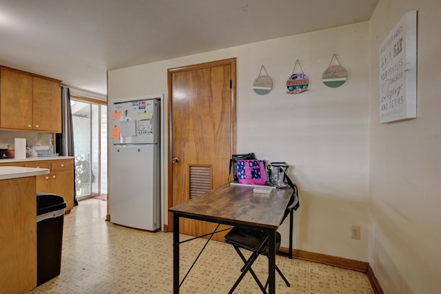 720 Kentland Dr, Neosho, MO 64850 - kitchen with freestanding refrigerator, light countertops, light flooring, and brown cabinetry