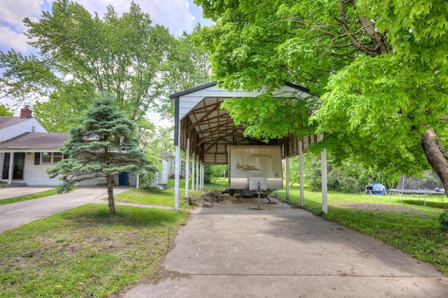 720 Kentland Dr, Neosho, MO 64850 - view of home's community featuring a yard, concrete driveway, a detached carport, and a trampoline