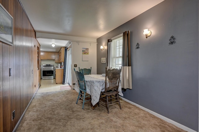 720 Kentland Dr, Neosho, MO 64850 - dining room with light carpet, wood walls, and baseboards