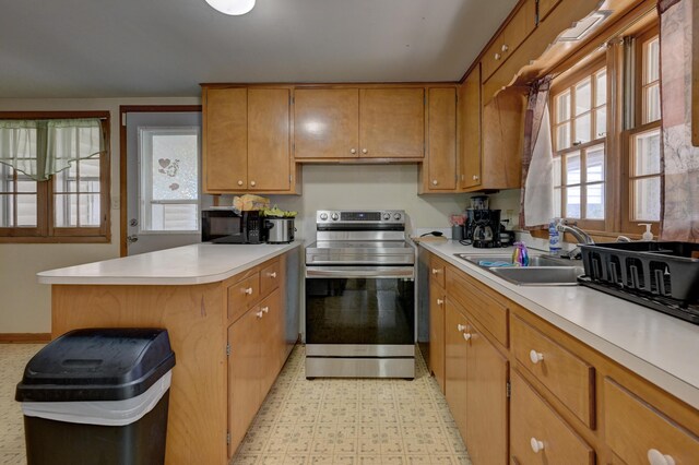 720 Kentland Dr, Neosho, MO 64850 - kitchen with stainless steel electric range, black microwave, a sink, light countertops, and brown cabinetry