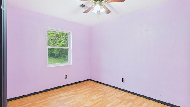 empty room featuring ceiling fan, light wood finished floors, and baseboards
