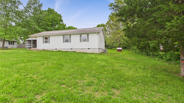 back of property featuring crawl space, a lawn, and central AC
