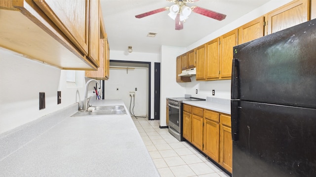 kitchen with freestanding refrigerator, electric stove, under cabinet range hood, a sink, and light countertops