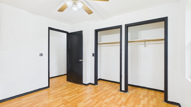 unfurnished bedroom with light wood finished floors, multiple closets, baseboards, and ceiling fan