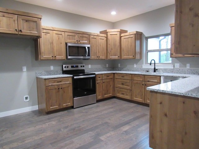748 Birdsong Ln, Marshfield, MO 65706 - kitchen with stainless steel appliances, a sink, light stone countertops, dark wood-style floors, and baseboards