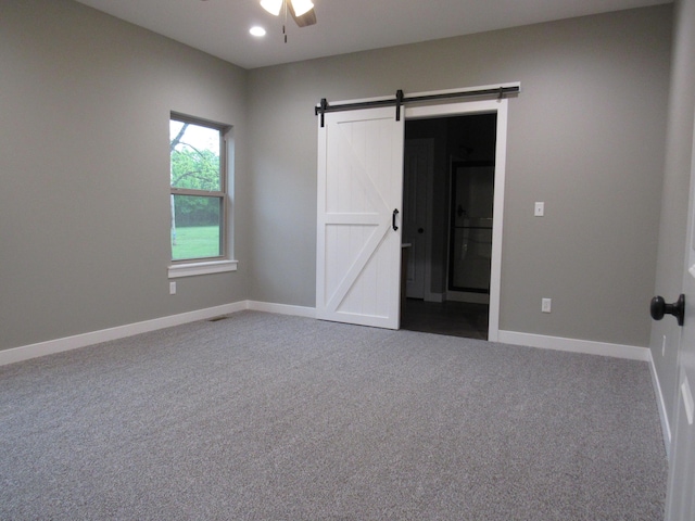 748 Birdsong Ln, Marshfield, MO 65706 - unfurnished bedroom featuring carpet, a barn door, baseboards, and a ceiling fan