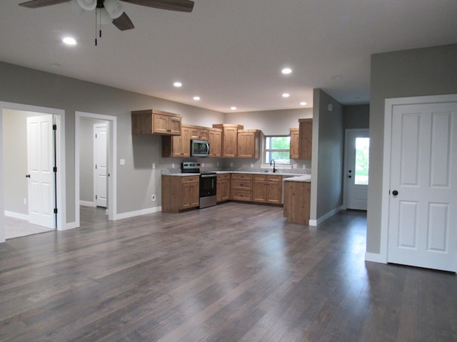 748 Birdsong Ln, Marshfield, MO 65706 - kitchen with stainless steel appliances, brown cabinetry, ceiling fan, a sink, and baseboards