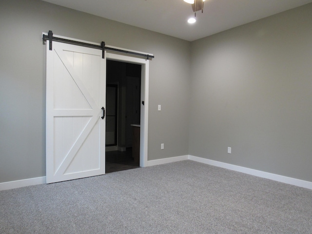 748 Birdsong Ln, Marshfield, MO 65706 - unfurnished bedroom with carpet flooring, a barn door, and baseboards