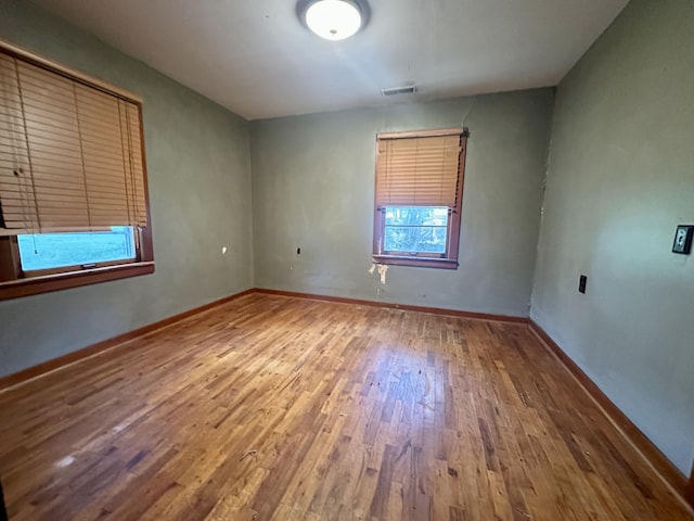 unfurnished room featuring wood-type flooring and baseboards