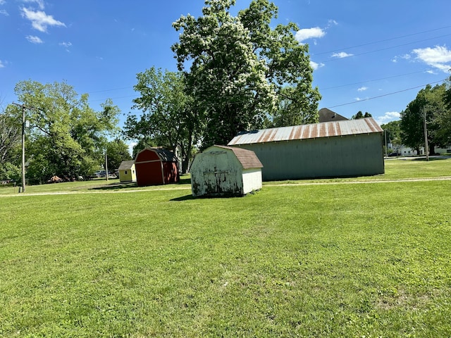 view of green lawn with an outdoor structure and a storage shed