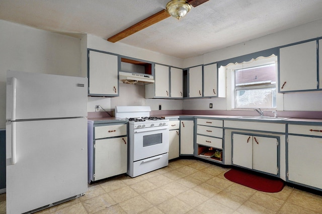 kitchen featuring white appliances, under cabinet range hood, beam ceiling, a sink, and light flooring