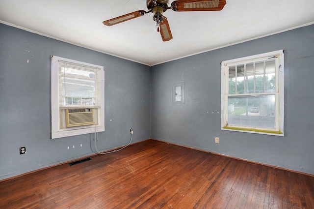 empty room featuring a ceiling fan, wood-type flooring, cooling unit, and ornamental molding