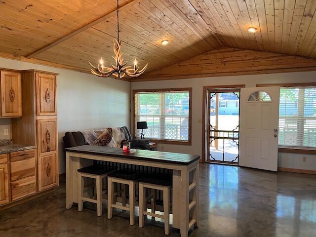 420 Maple St, Granby, MO 64844 - dining room featuring vaulted ceiling, plenty of natural light, a chandelier, wood ceiling, and concrete flooring