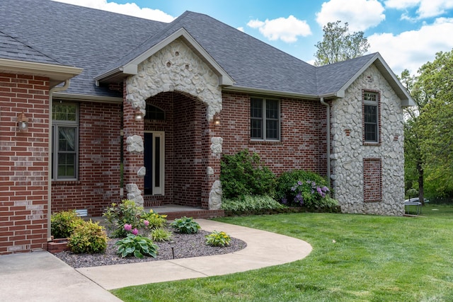 1099 E Julian St, Marshfield, MO 65706 - doorway to property featuring a yard, stone siding, brick siding, and a shingled roof