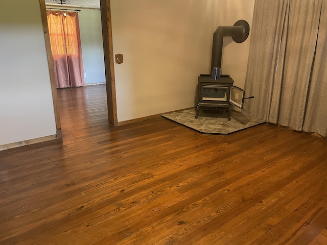 unfurnished living room with hardwood / wood-style floors and a wood stove