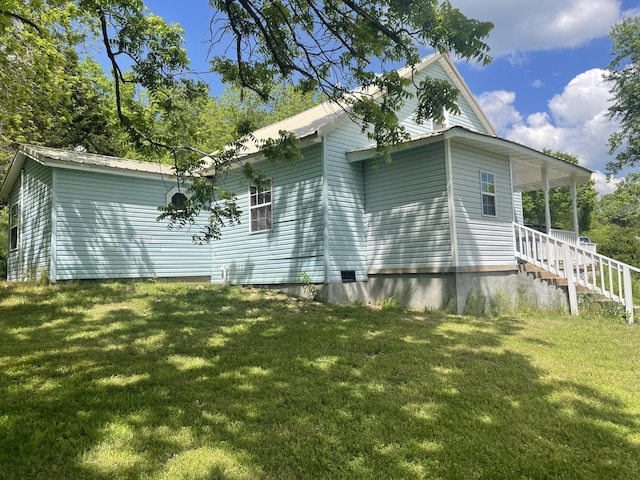 view of side of home with a yard and metal roof