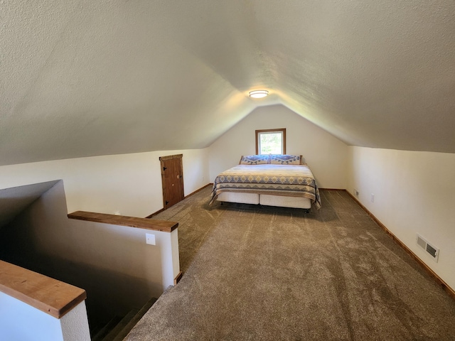 carpeted bedroom featuring vaulted ceiling and a textured ceiling