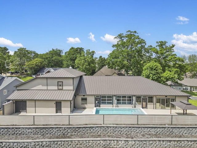 1970 Pointe Royale Dr, Branson, MO 65616 - back of house featuring an outdoor pool, a fenced backyard, metal roof, and a sunroom
