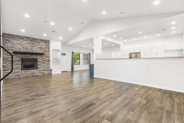 1970 Pointe Royale Dr, Branson, MO 65616 - unfurnished living room featuring a stone fireplace, wood finished floors, high vaulted ceiling, and recessed lighting