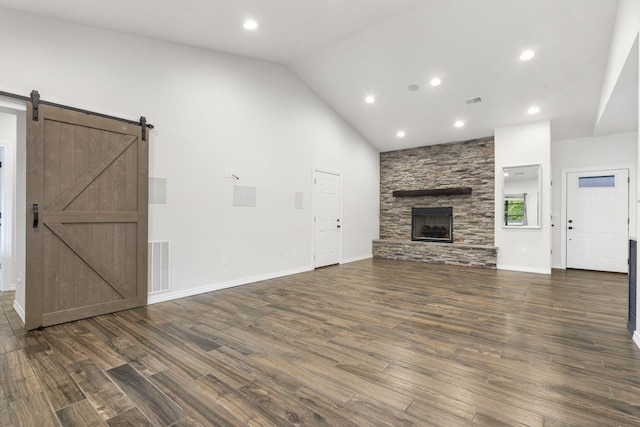 1970 Pointe Royale Dr, Branson, MO 65616 - unfurnished living room featuring dark wood finished floors, a barn door, a stone fireplace, baseboards, and recessed lighting