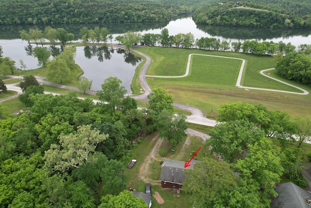 aerial view of property and surrounding area with a large body of water and a heavily wooded area