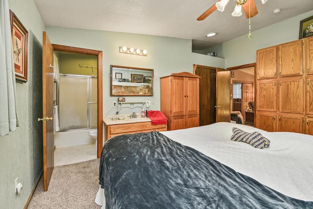bedroom with light colored carpet, a sink, a textured ceiling, ensuite bathroom, and a ceiling fan
