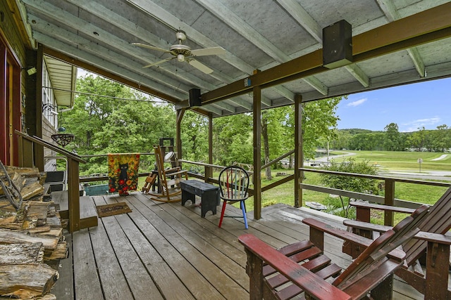 wooden terrace with ceiling fan and view of wooded area