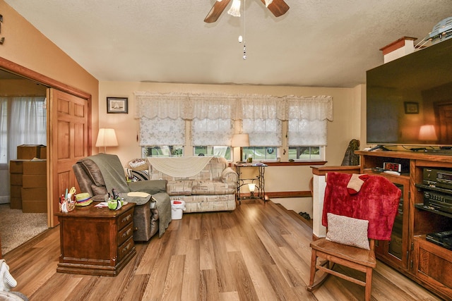 living room featuring a ceiling fan, wood finished floors, and a textured ceiling
