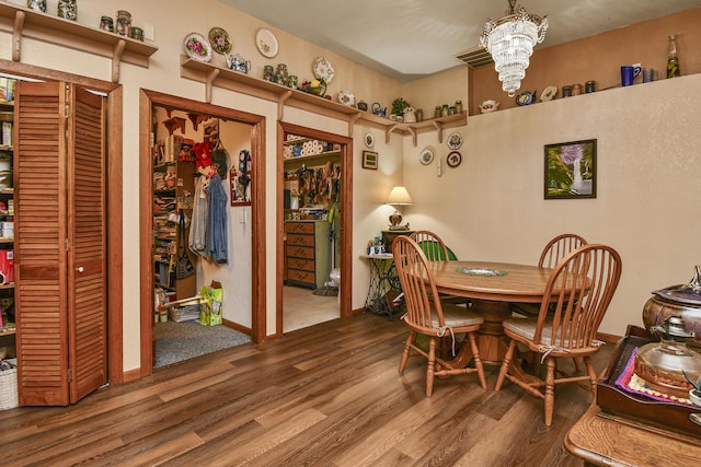 dining space with wood finished floors and a chandelier