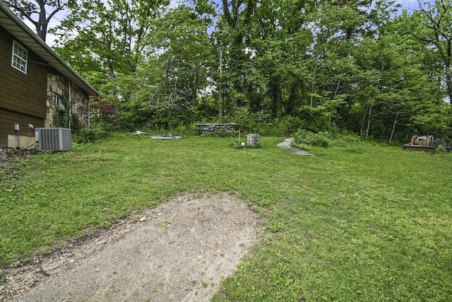 view of grassy yard with central AC