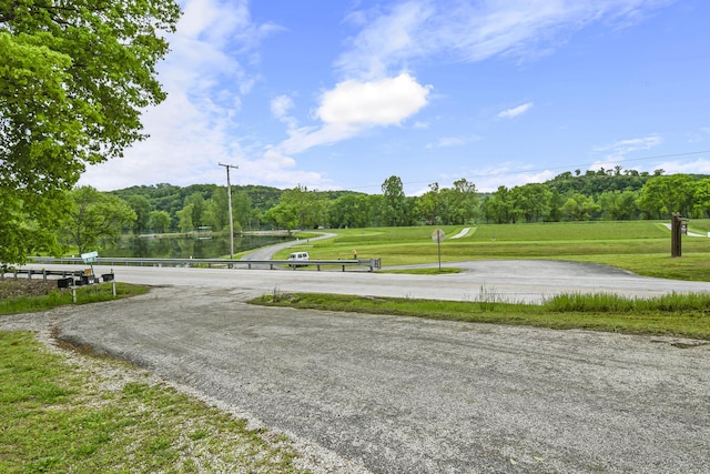view of home's community with a lawn and view of wooded area