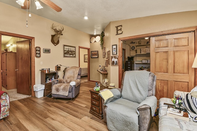 living area with light wood finished floors and ceiling fan