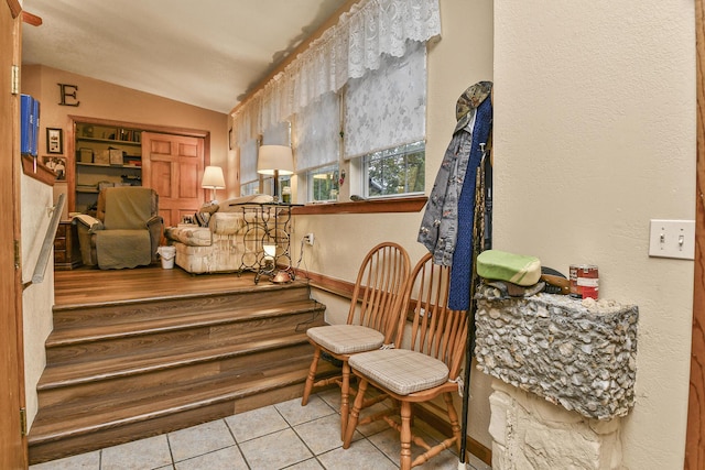 living area featuring tile patterned floors and vaulted ceiling