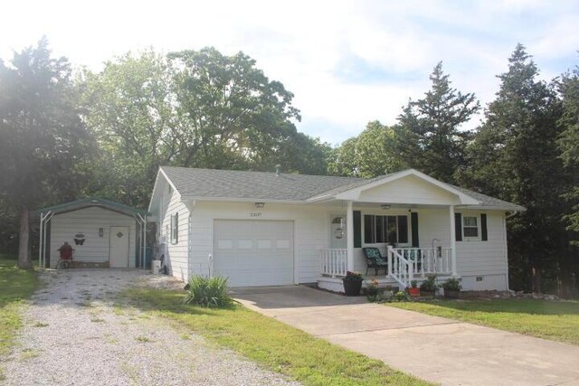 23197 Oakwood Cir, Hermitage, MO 65668 - single story home featuring covered porch, a detached carport, driveway, and an attached garage