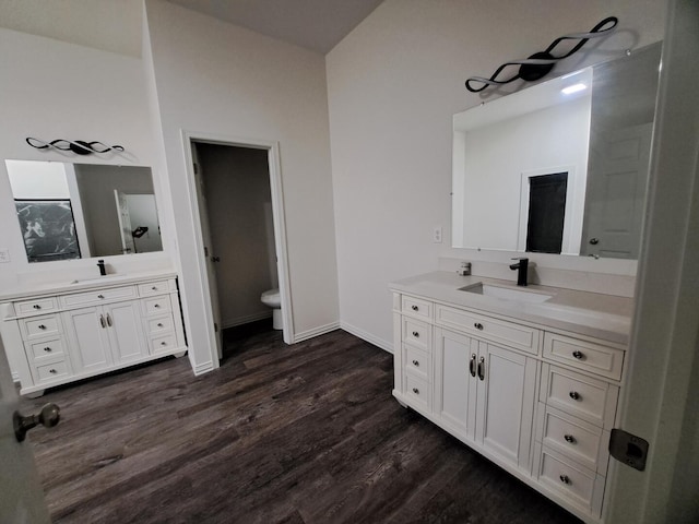 137 Vista Ln, Granby, MO 64844 - bathroom featuring wood finished floors, two vanities, toilet, and baseboards