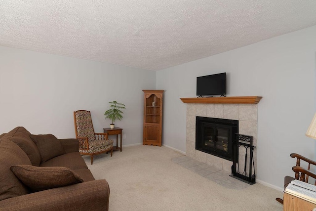 living area with carpet, a textured ceiling, a fireplace, and baseboards