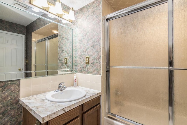 bathroom featuring vanity, tasteful backsplash, and tile walls