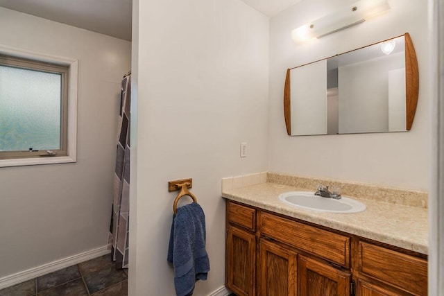 bathroom with vanity, baseboards, and curtained shower