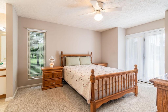bedroom featuring light carpet, a textured ceiling, ceiling fan, and baseboards