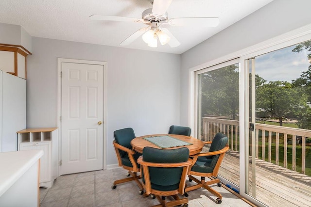 dining space featuring a desk, a ceiling fan, and light tile patterned floors